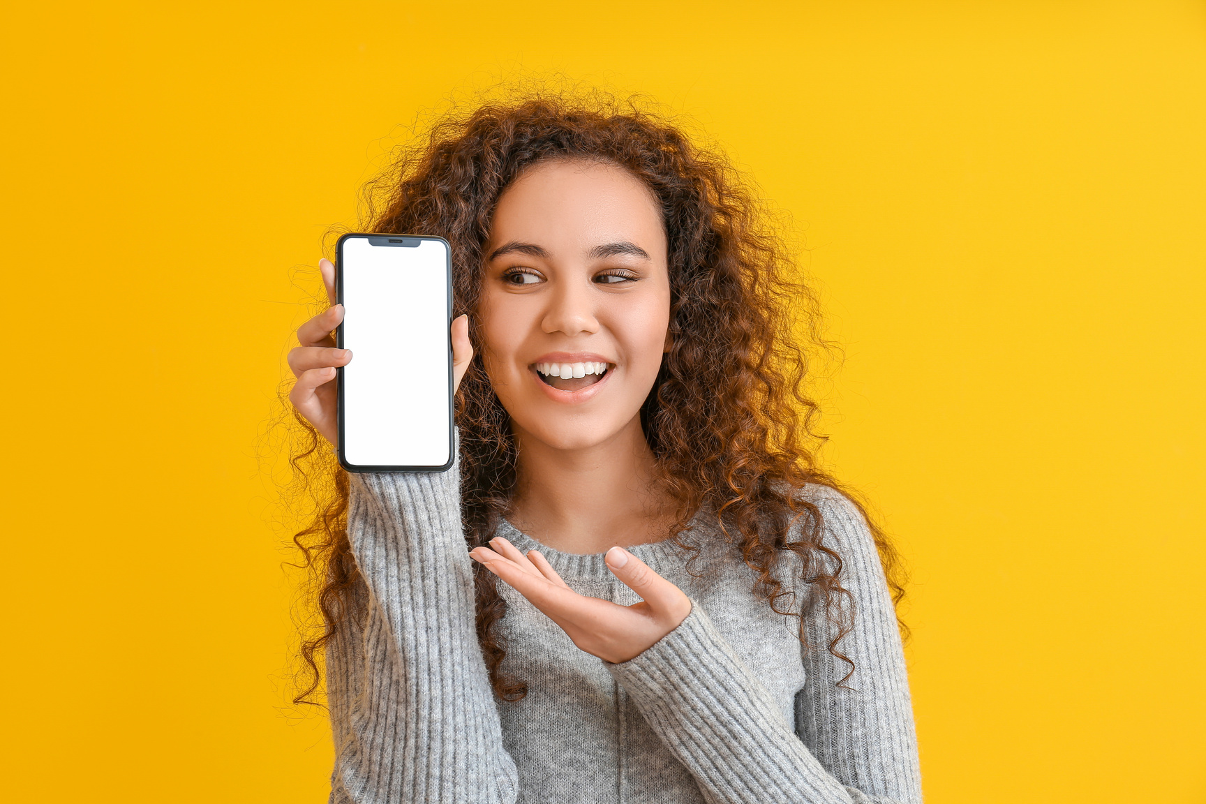 Woman Showing Mobile Phone on Orange Background
